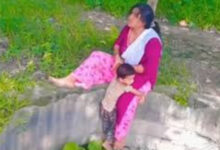 woman sitting with child on the edge of well for reels