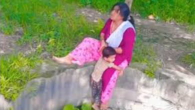 woman sitting with child on the edge of well for reels