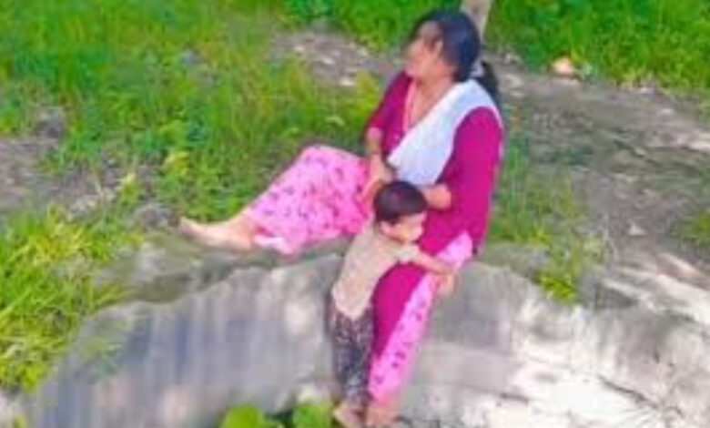 woman sitting with child on the edge of well for reels